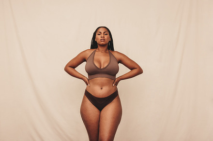 Self-confident young woman standing in brown underwear